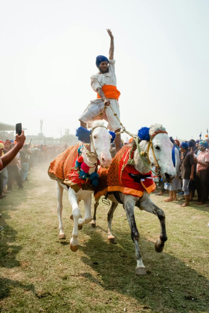 A rider performs a daring equestrian stunt during a vibrant festival in Anandpur Sahib, India.