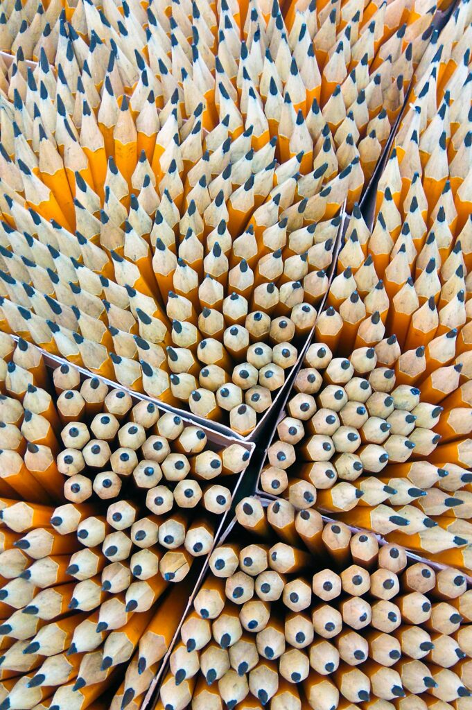 Close-up of sharpened wooden pencils organized in a geometric pattern.